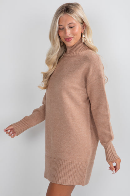 Woman wearing a brown sweater dress against a white background