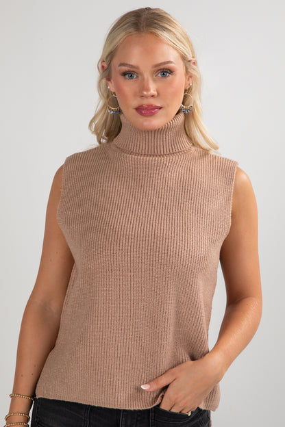 Woman wearing a beige sleeveless ribbed sweater against a plain background