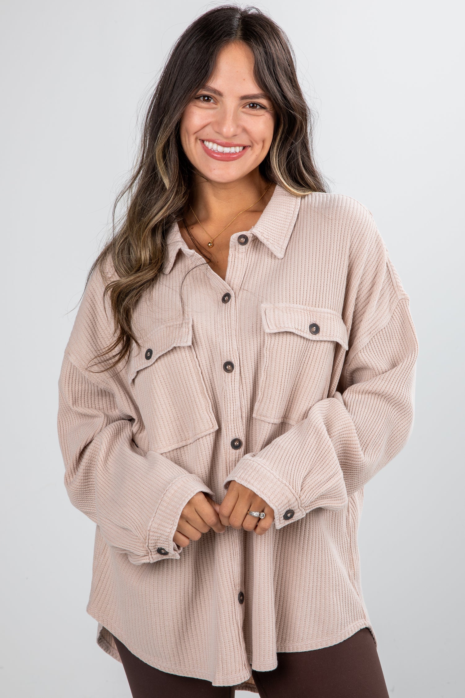 Woman wearing a beige corduroy shirt on a white background