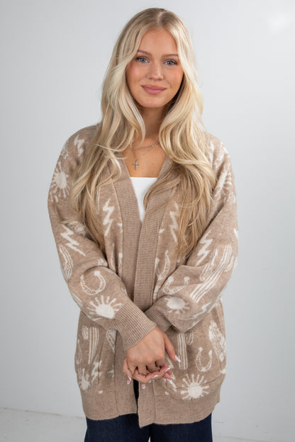 Woman wearing a beige patterned cardigan against a white background