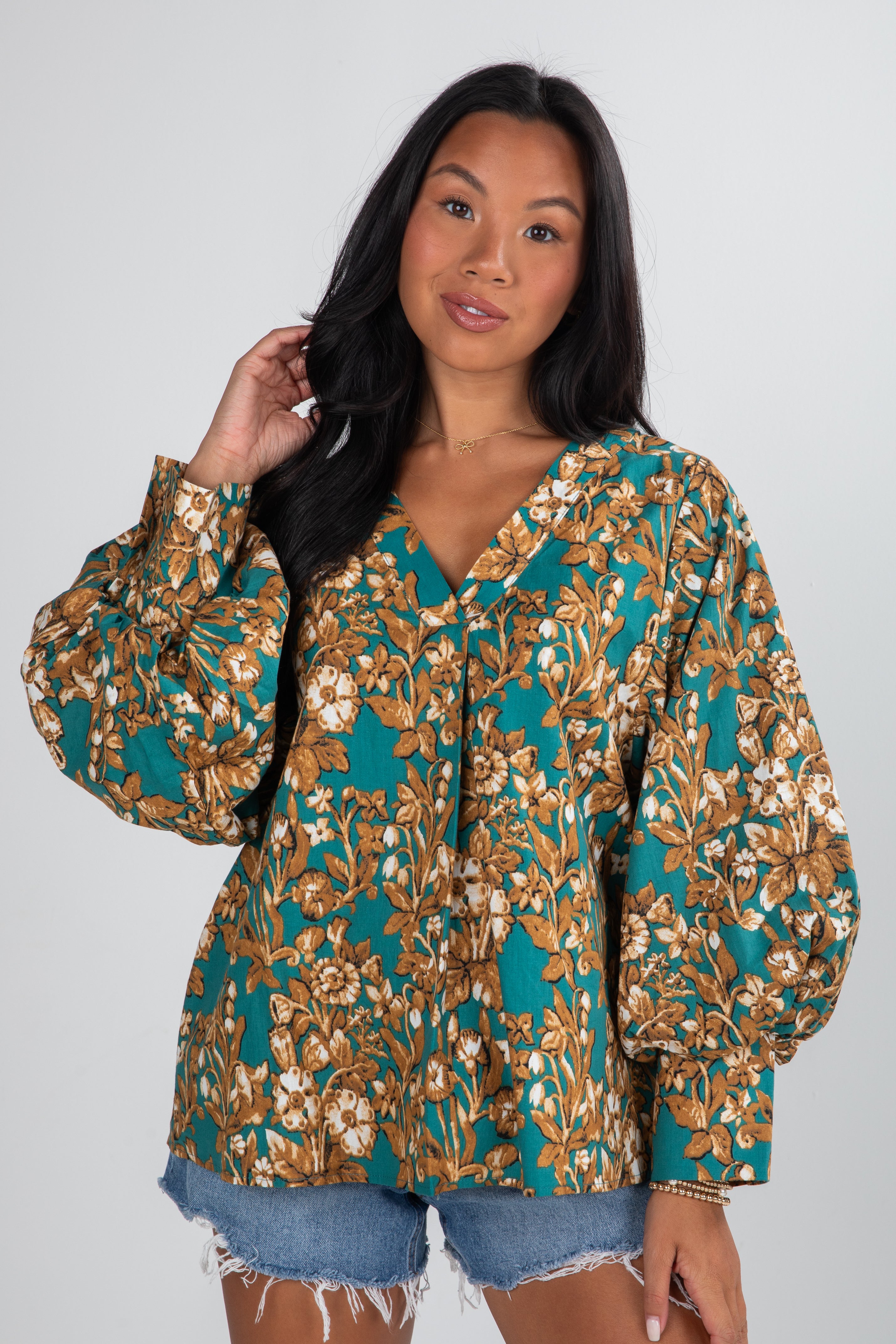 Woman wearing a floral blouse with a plain background