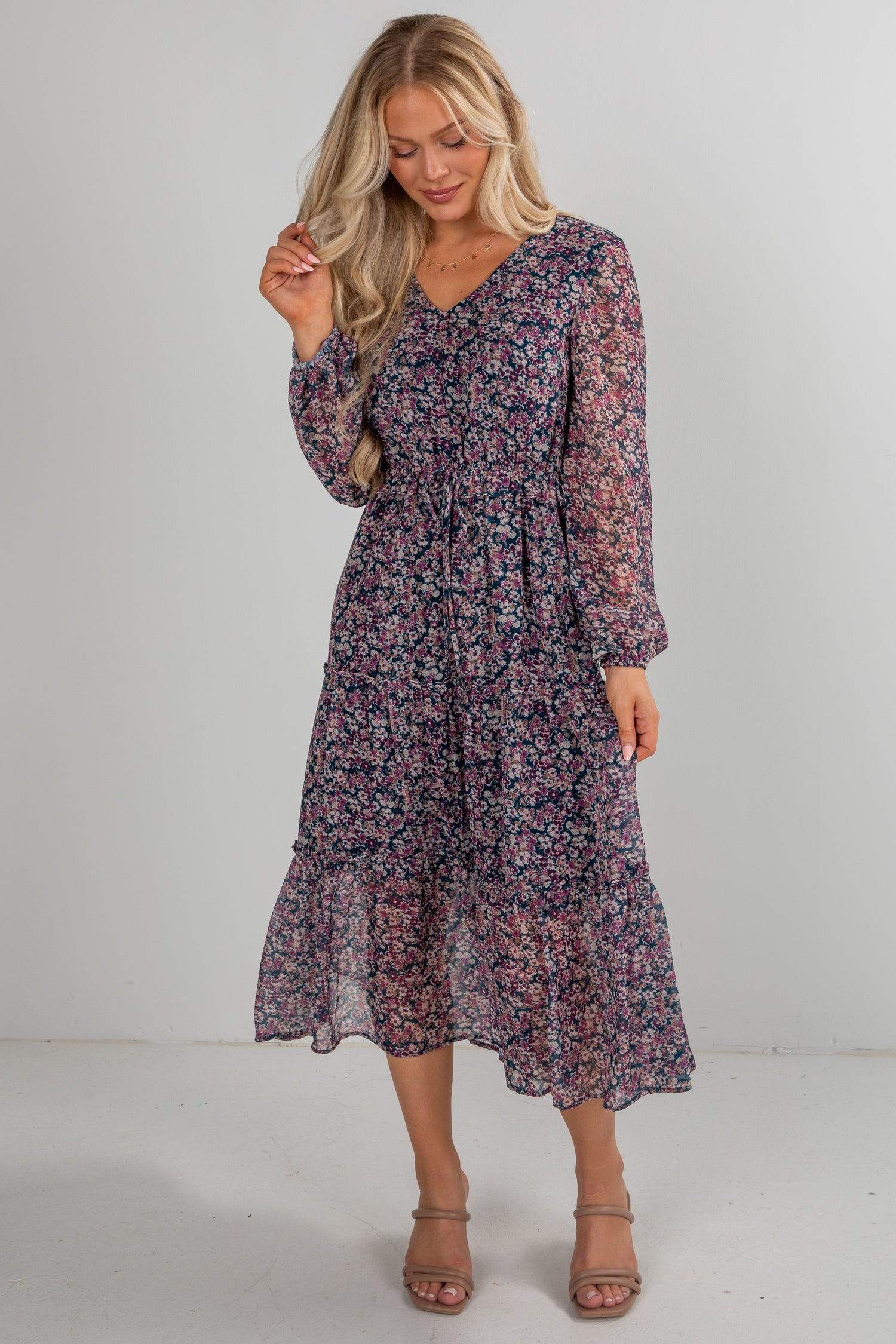 Woman wearing a floral dress against a plain background