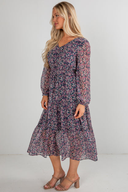 Woman wearing a floral dress against a plain background