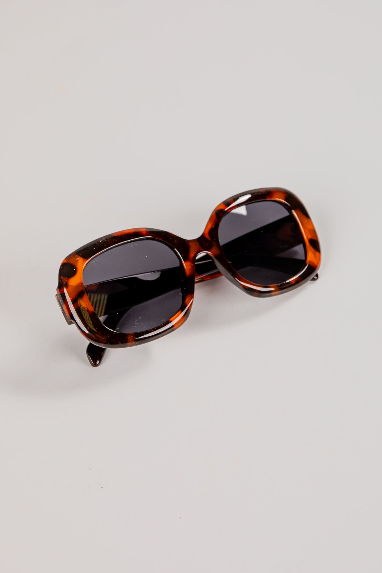 Tortoiseshell sunglasses on a light gray background