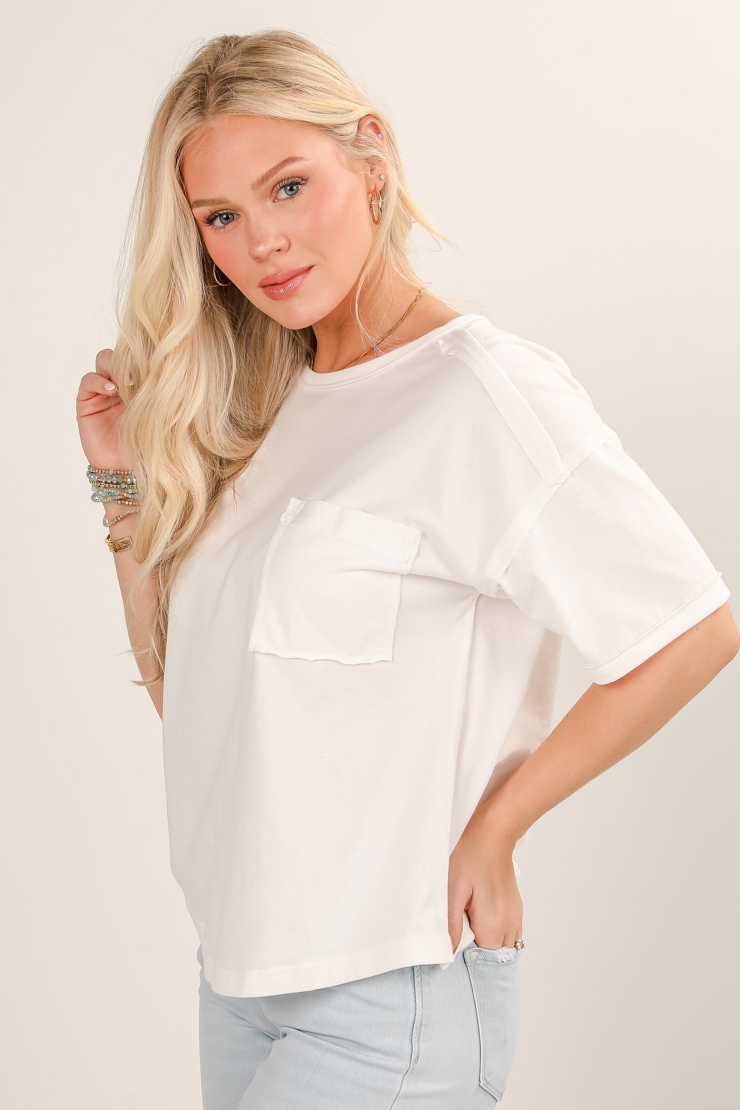 Woman wearing a white oversized shirt with a neutral background