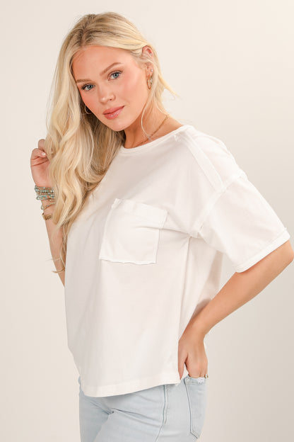Woman wearing a white oversized shirt with a neutral background