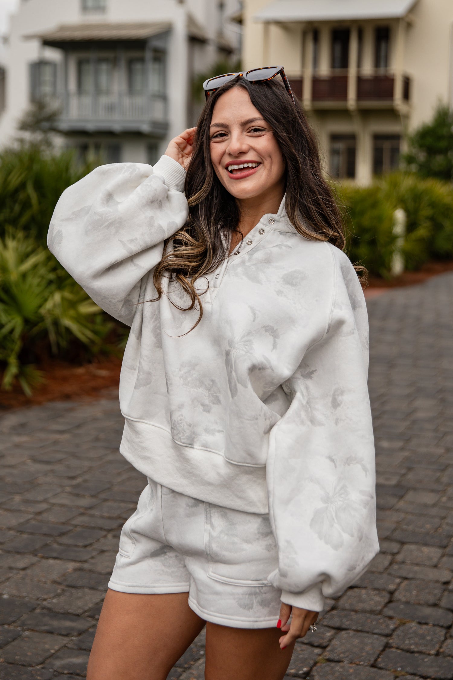 Woman wearing a white outfit with a textured pattern on a street.