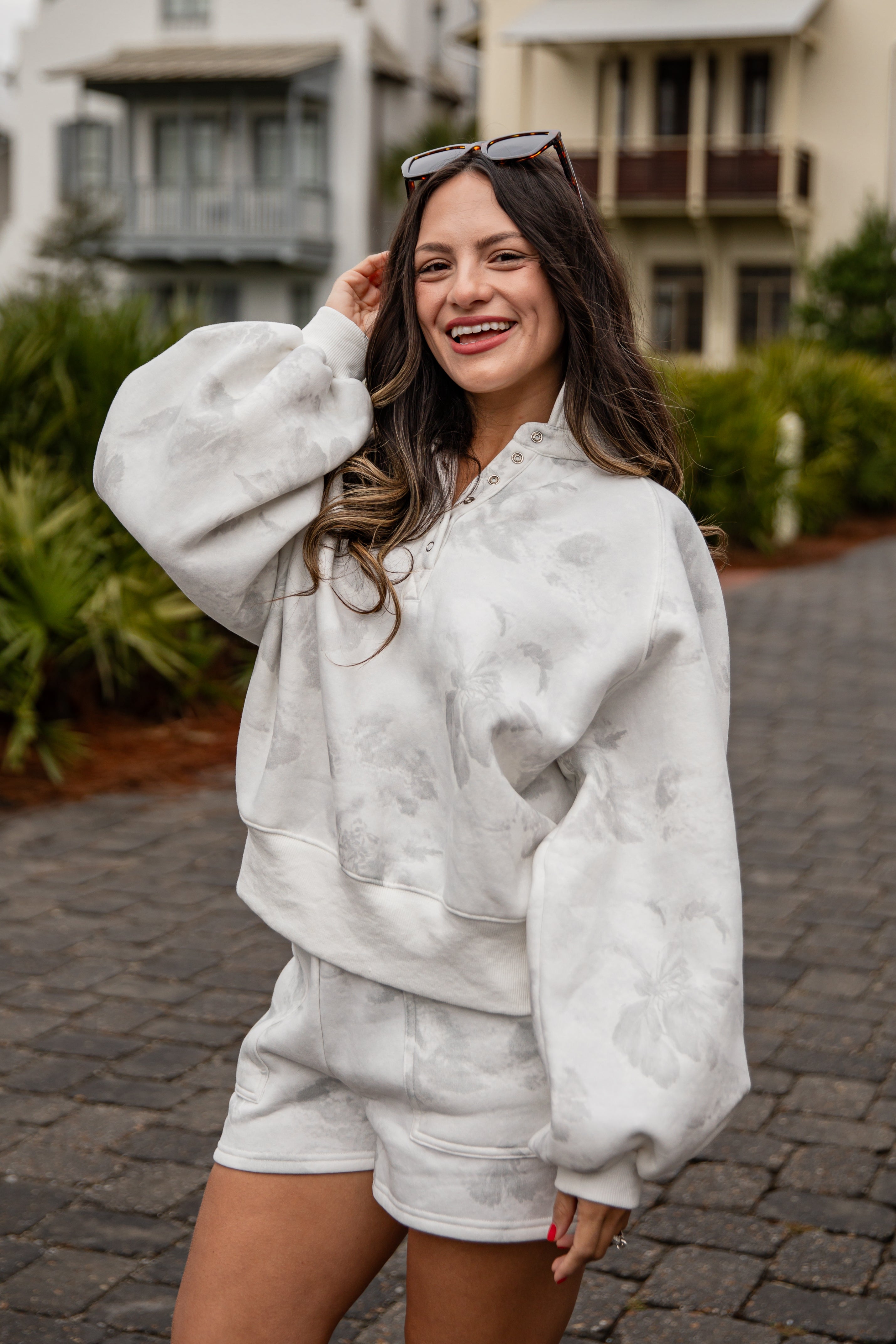 Woman wearing a white outfit with a textured pattern on a street.