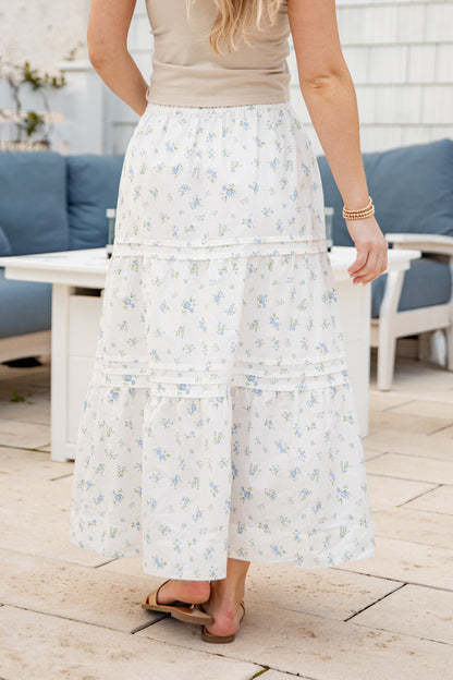 Person wearing a floral skirt on a patio