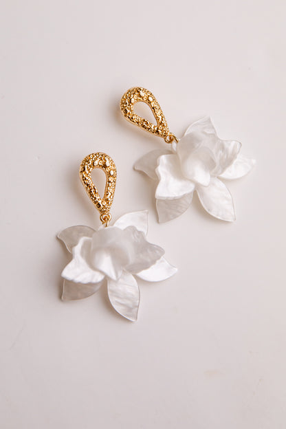 Pair of floral earrings with gold accents on a light background