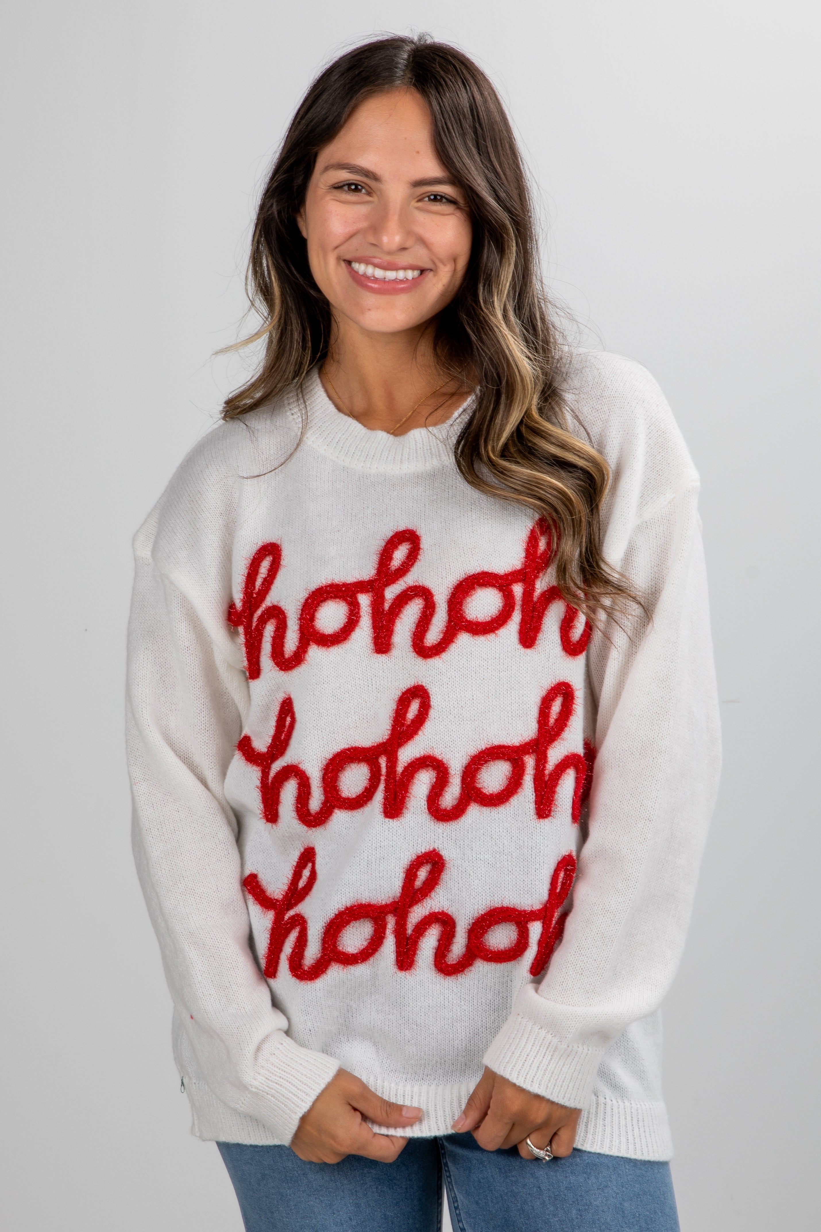 Woman wearing a white sweater with red &