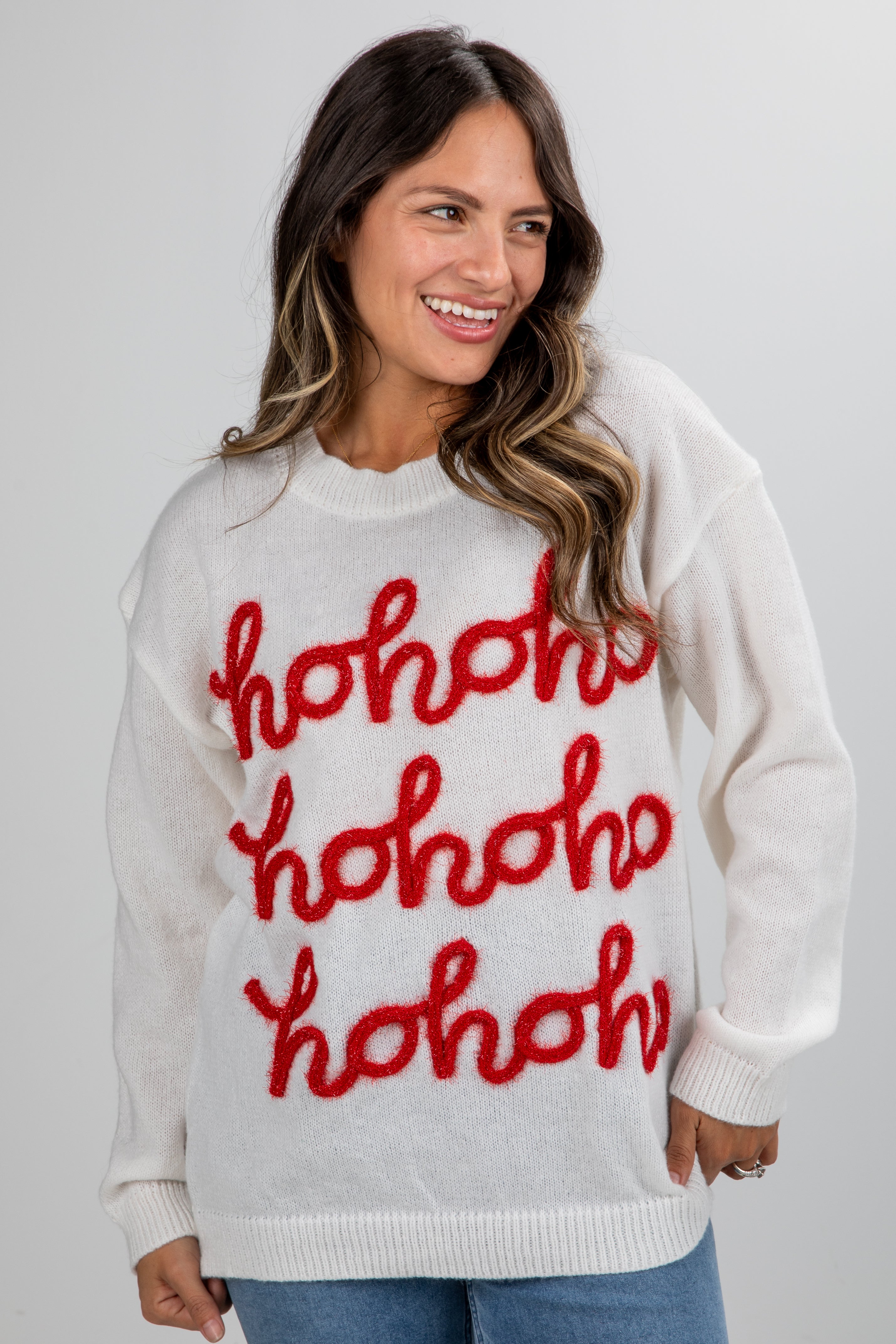 Woman wearing a white sweater with red &