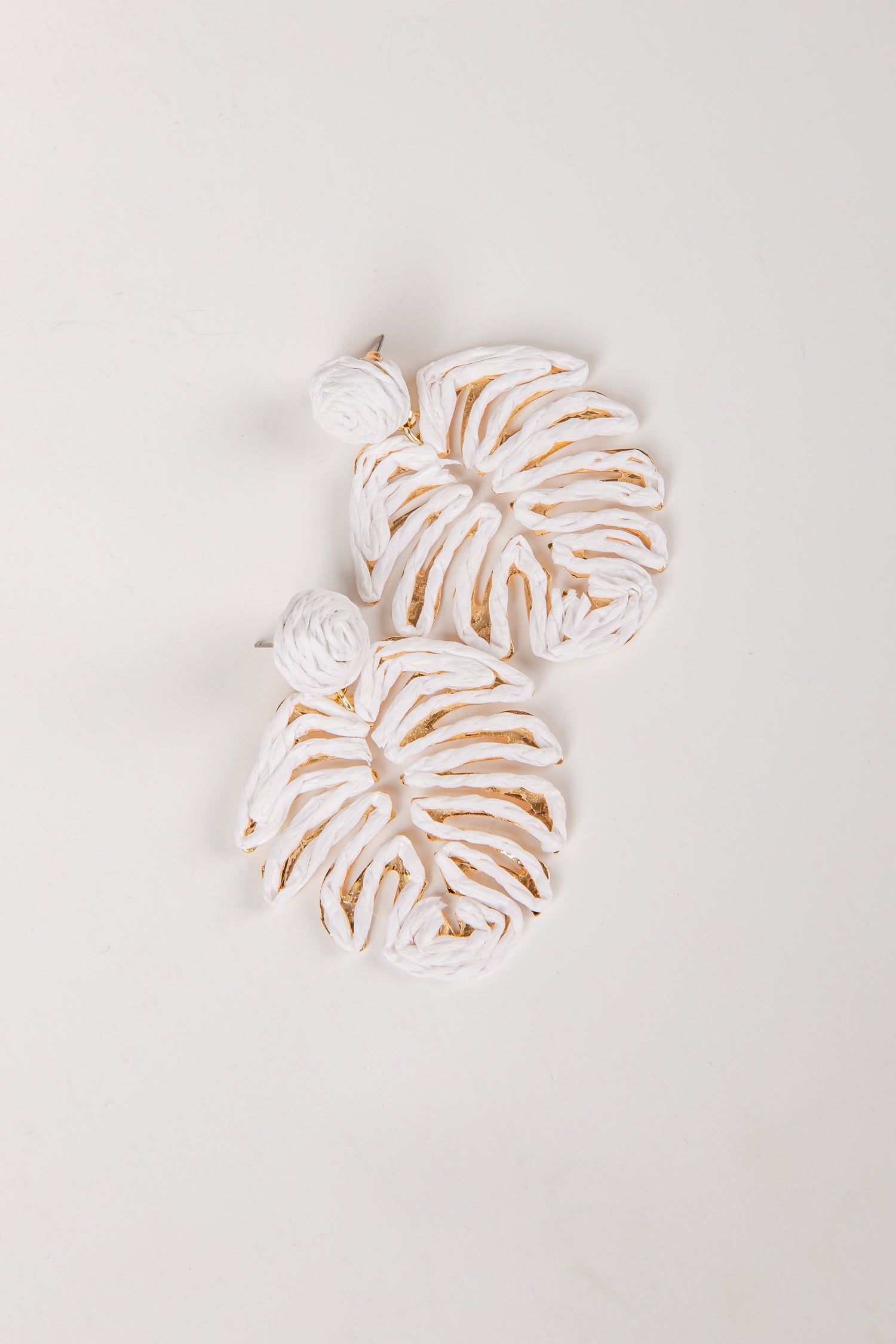 Decorative leaf-shaped cookies with white icing on a light gray background