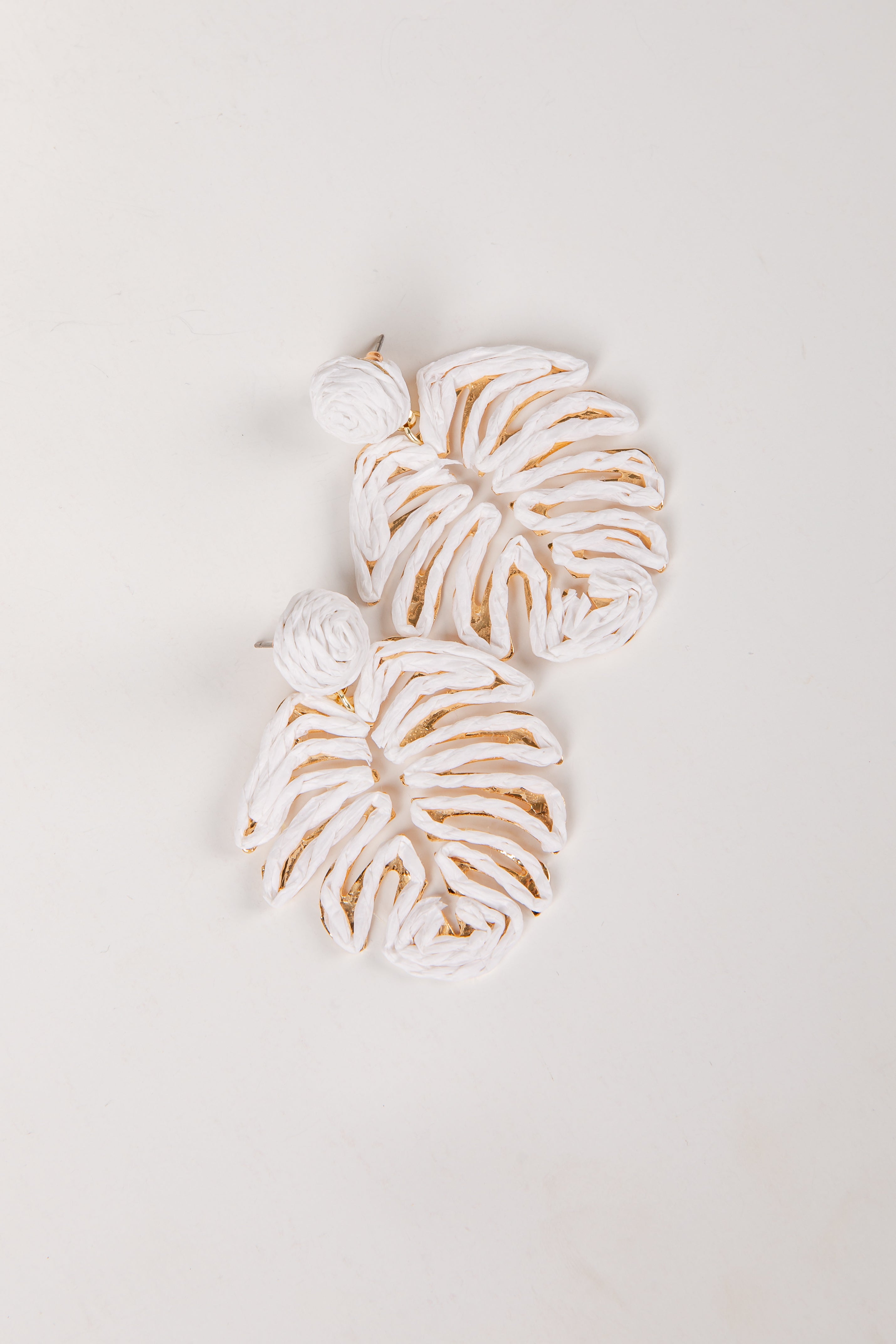 Decorative leaf-shaped cookies with white icing on a light gray background
