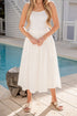 Woman in a white dress standing by a pool