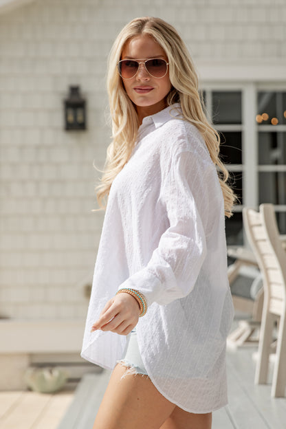 Woman wearing a white shirt and sunglasses outdoors