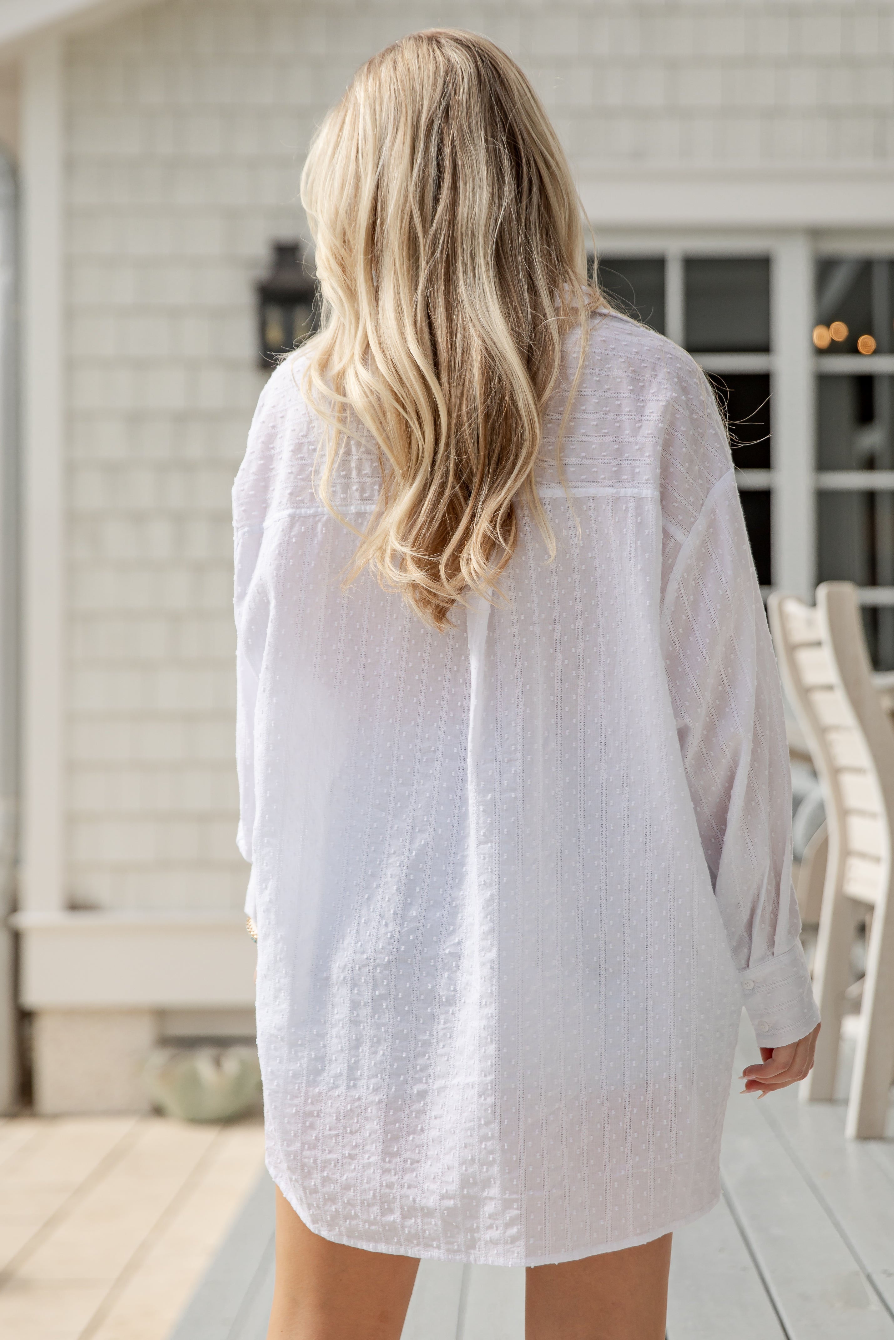 Person wearing a white shirt on a wooden deck