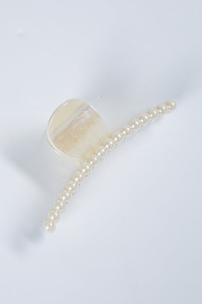 Transparent hair clip with a chain of pearls on a white background