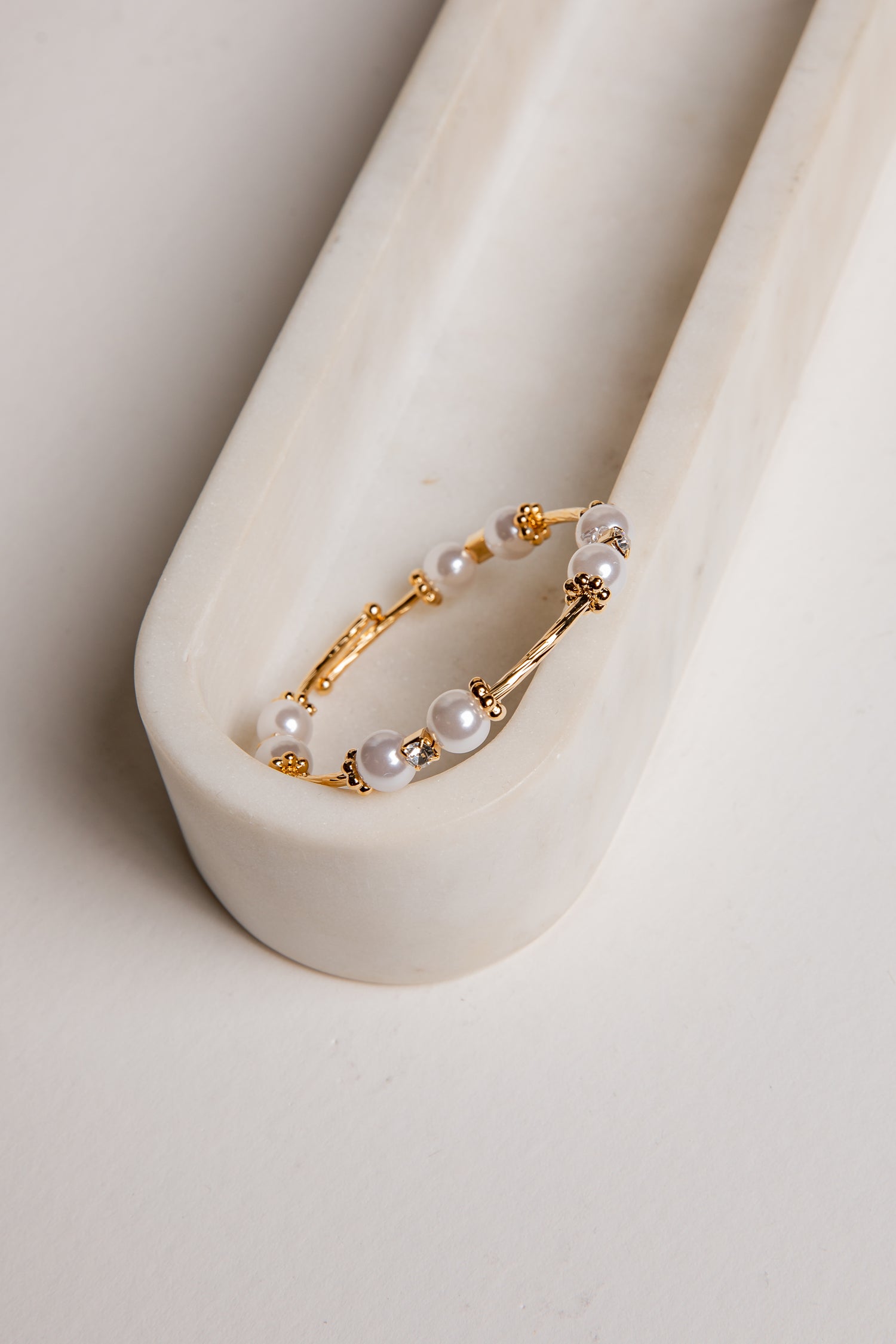 Gold hoop earring with pearls on a white background