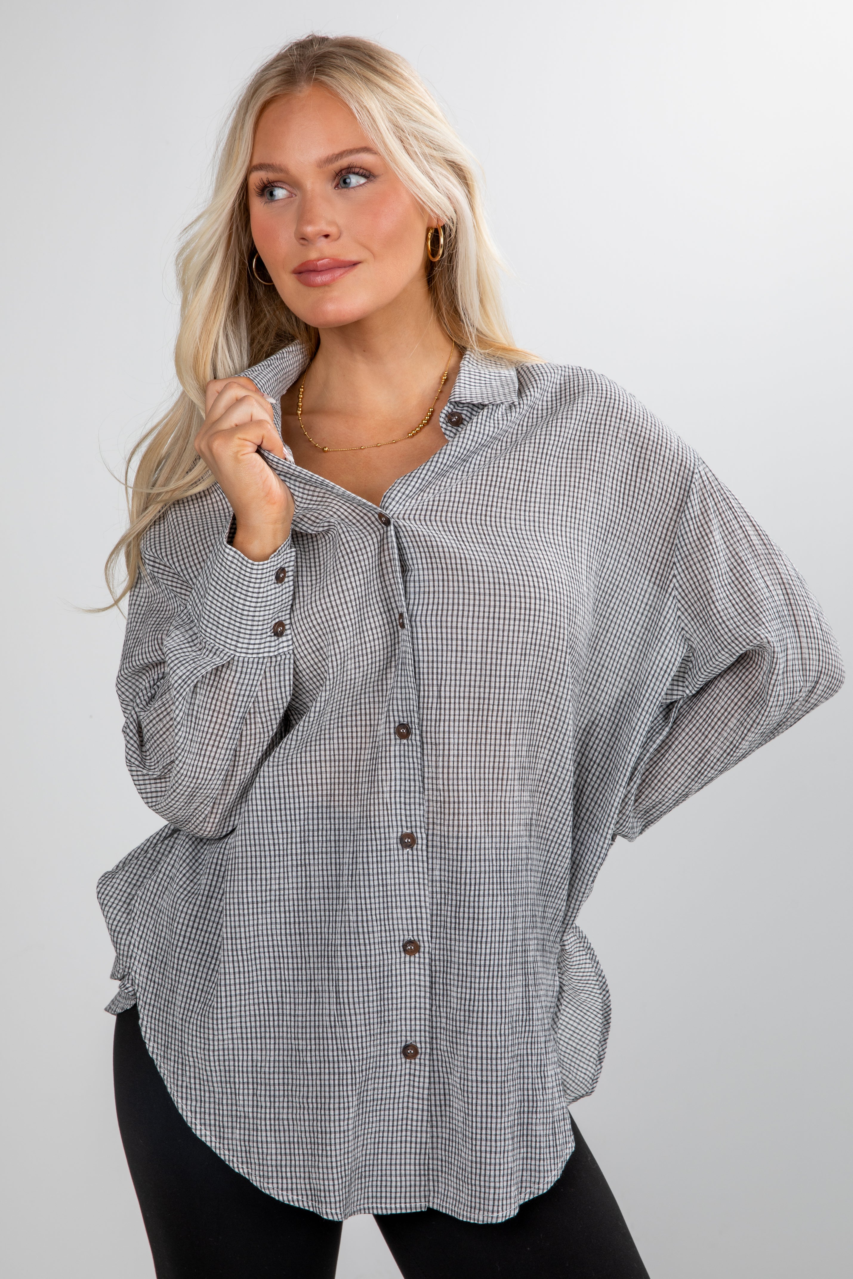 Woman wearing a checkered shirt with a plain background