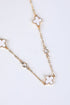 Gold chain necklace with clover-shaped pendants on a white background
