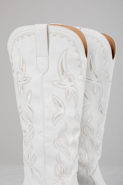 White embroidered cowboy boot on a gray background