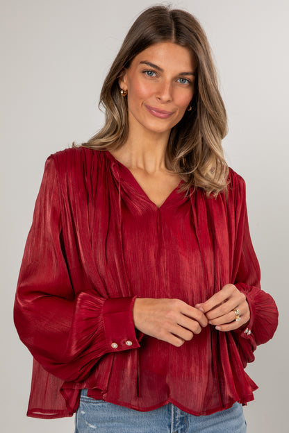 Woman wearing a red blouse with a plain background