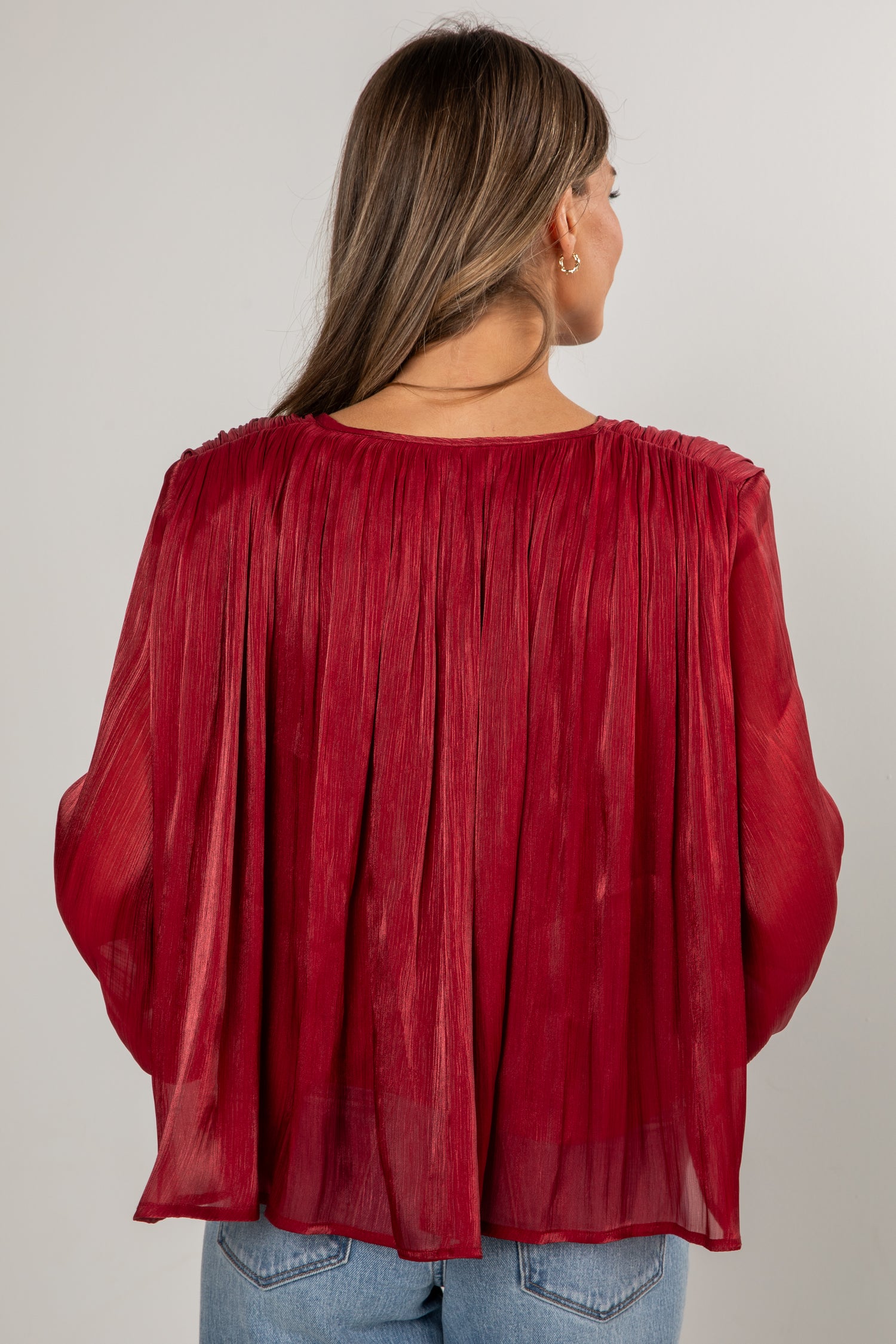 Red sheer blouse worn by a person on a plain background