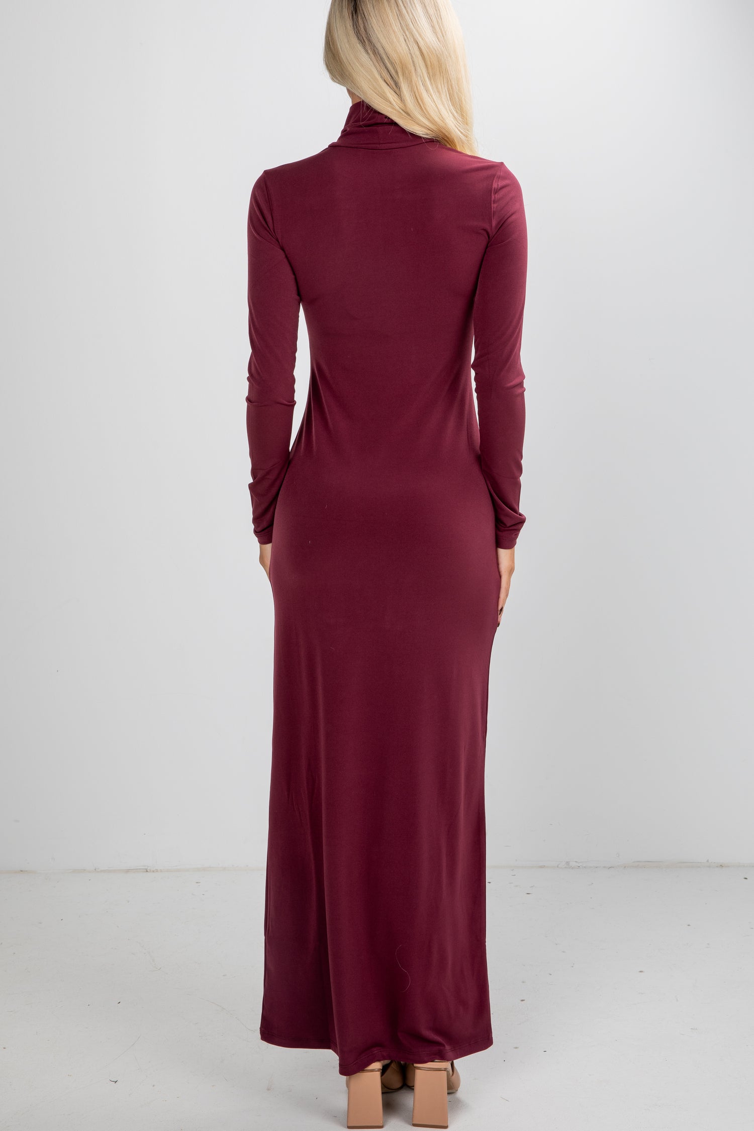 Burgundy long-sleeve dress worn by a person on a white background