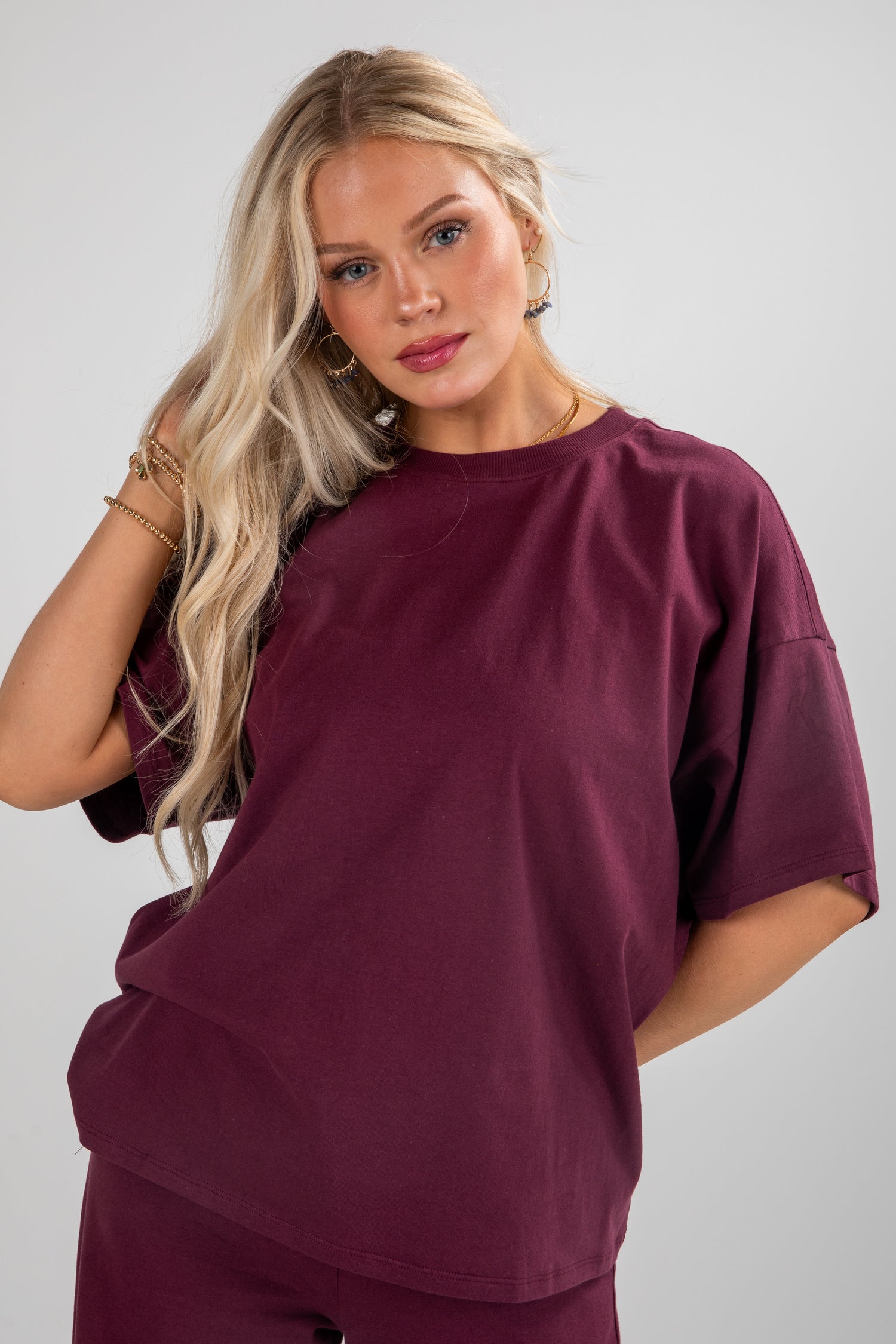 Woman wearing a burgundy outfit against a plain background