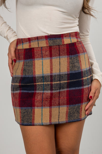 Plaid skirt worn by a person on a plain background