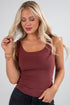 Woman wearing a maroon tank top against a plain background
