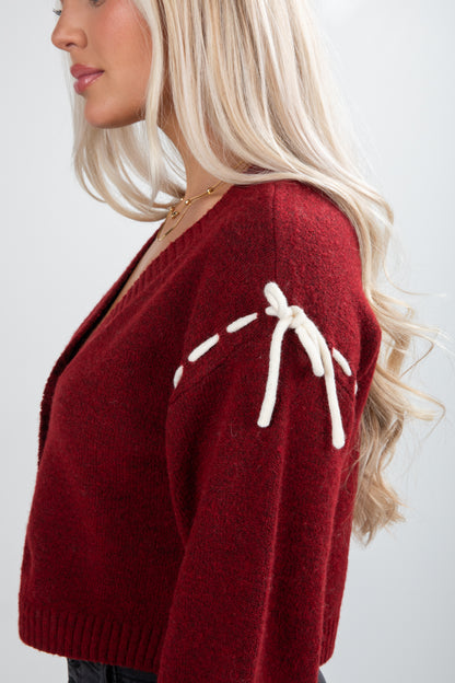 Red sweater with white accents worn by a person on a plain background