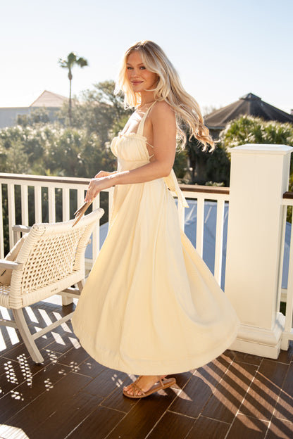Woman in a white dress standing on a balcony with a scenic background