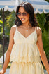 Woman wearing a yellow dress with sunglasses outdoors