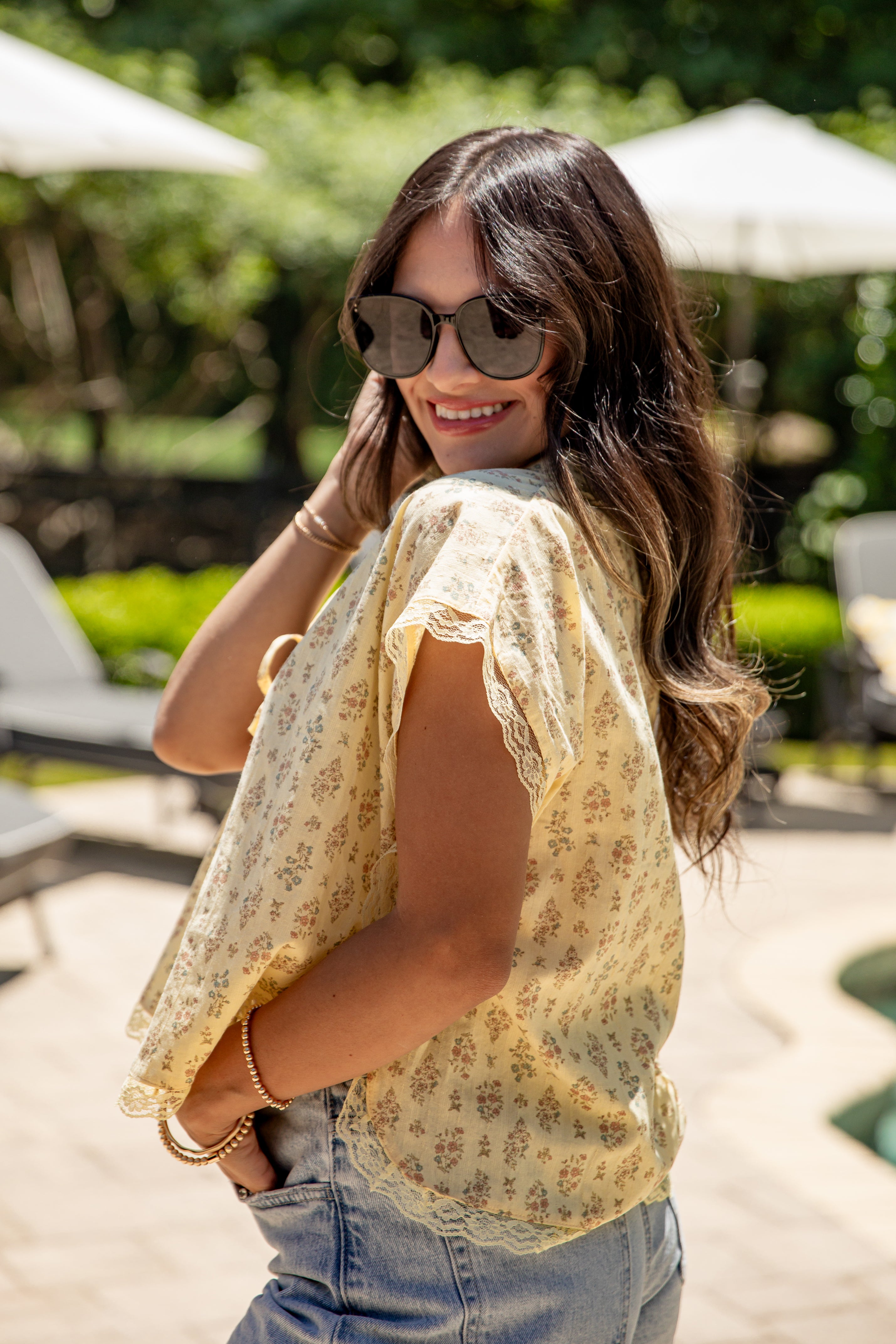 Woman wearing a floral blouse and sunglasses outdoors