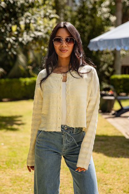 Woman wearing sunglasses and a light-colored jacket outdoors