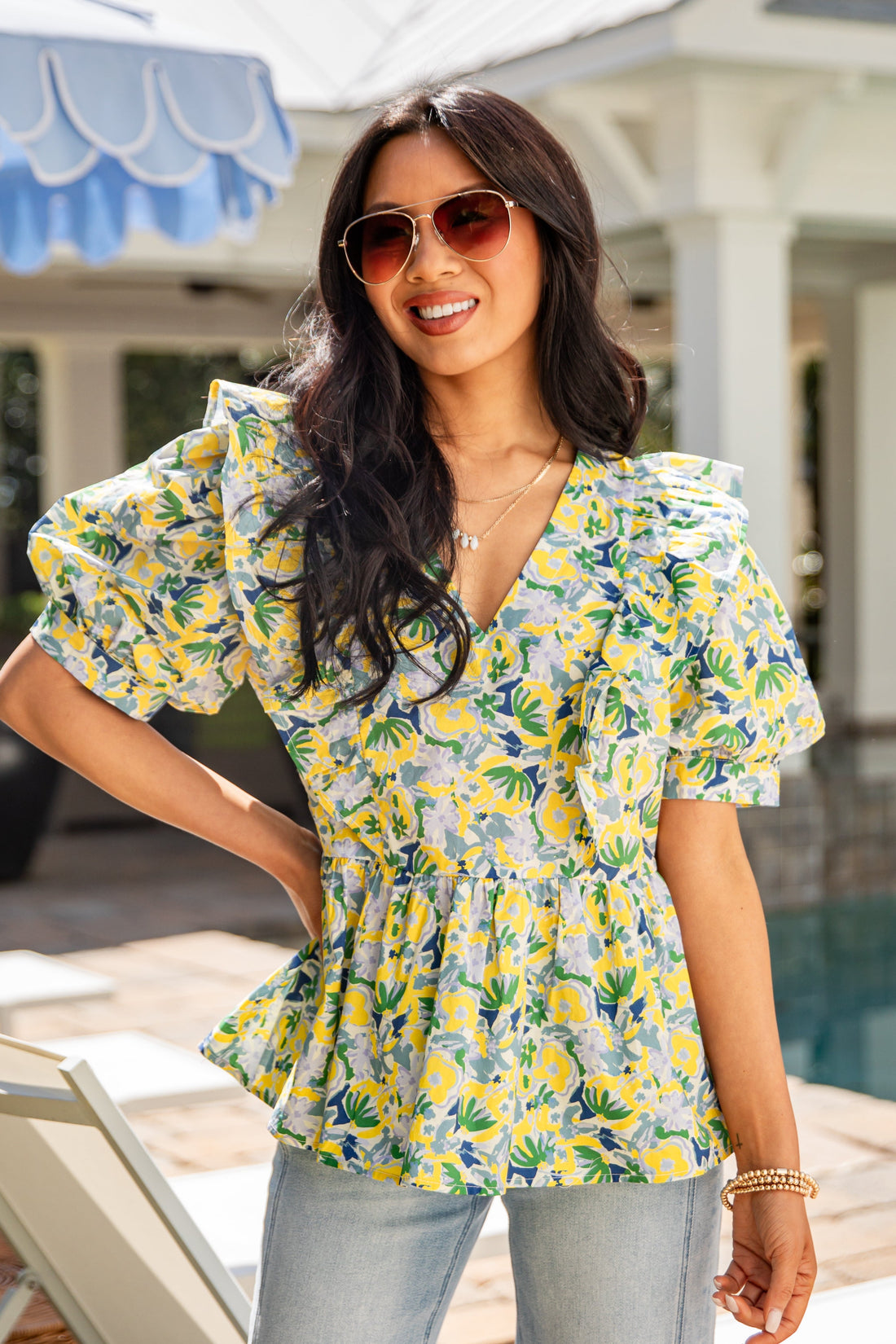 Woman wearing a floral blouse by a poolside