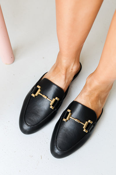 model wearing Gucci dupe black faux leather loafers with gold buckle detail