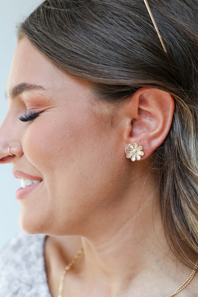 model wearing gold flower earrings