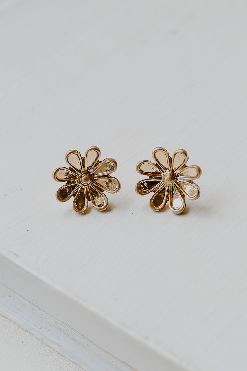 flat lay of gold flower earrings