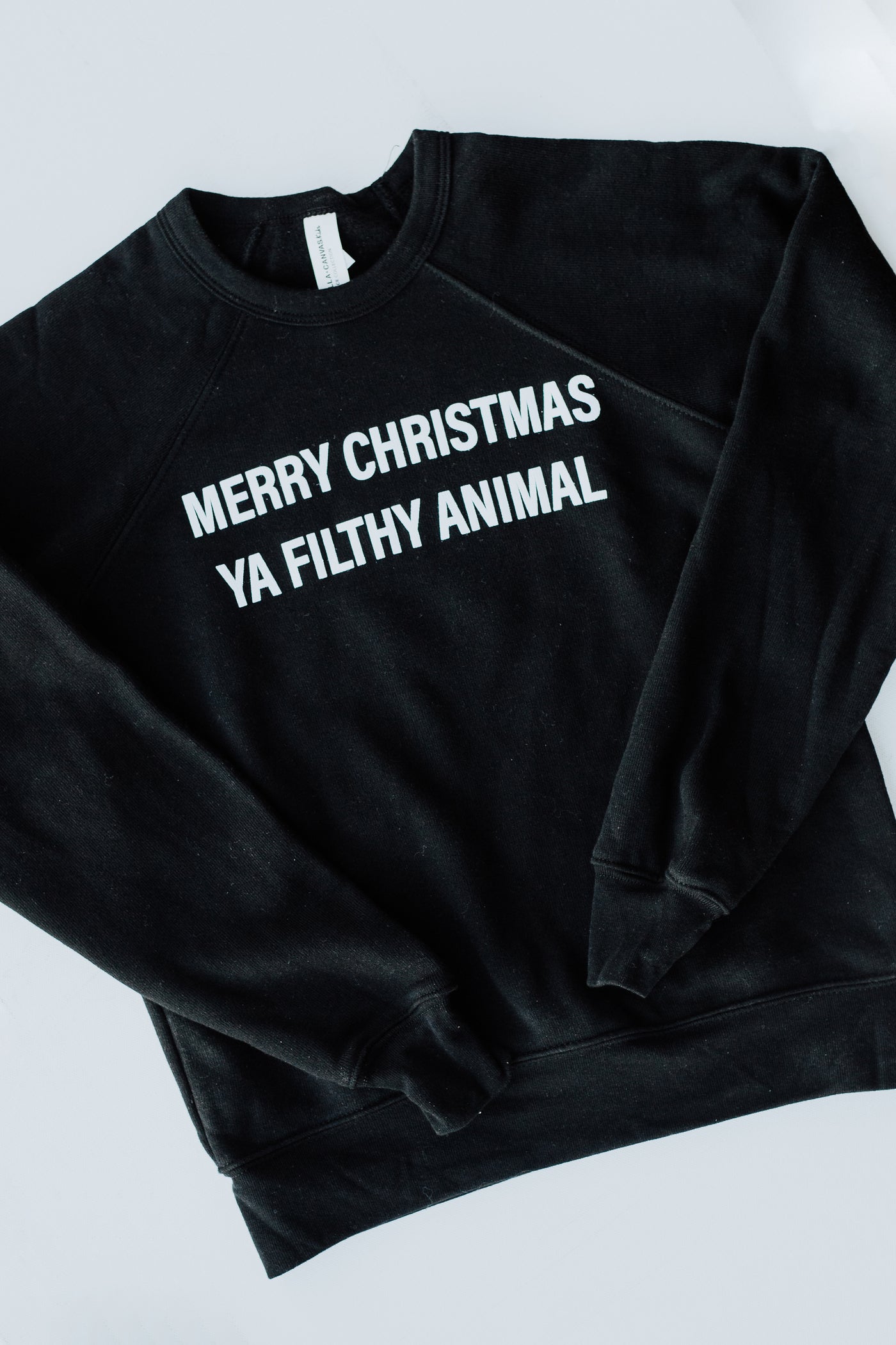 flat lay of the Youth Merry Christmas Ya Filthy Animal Pullover