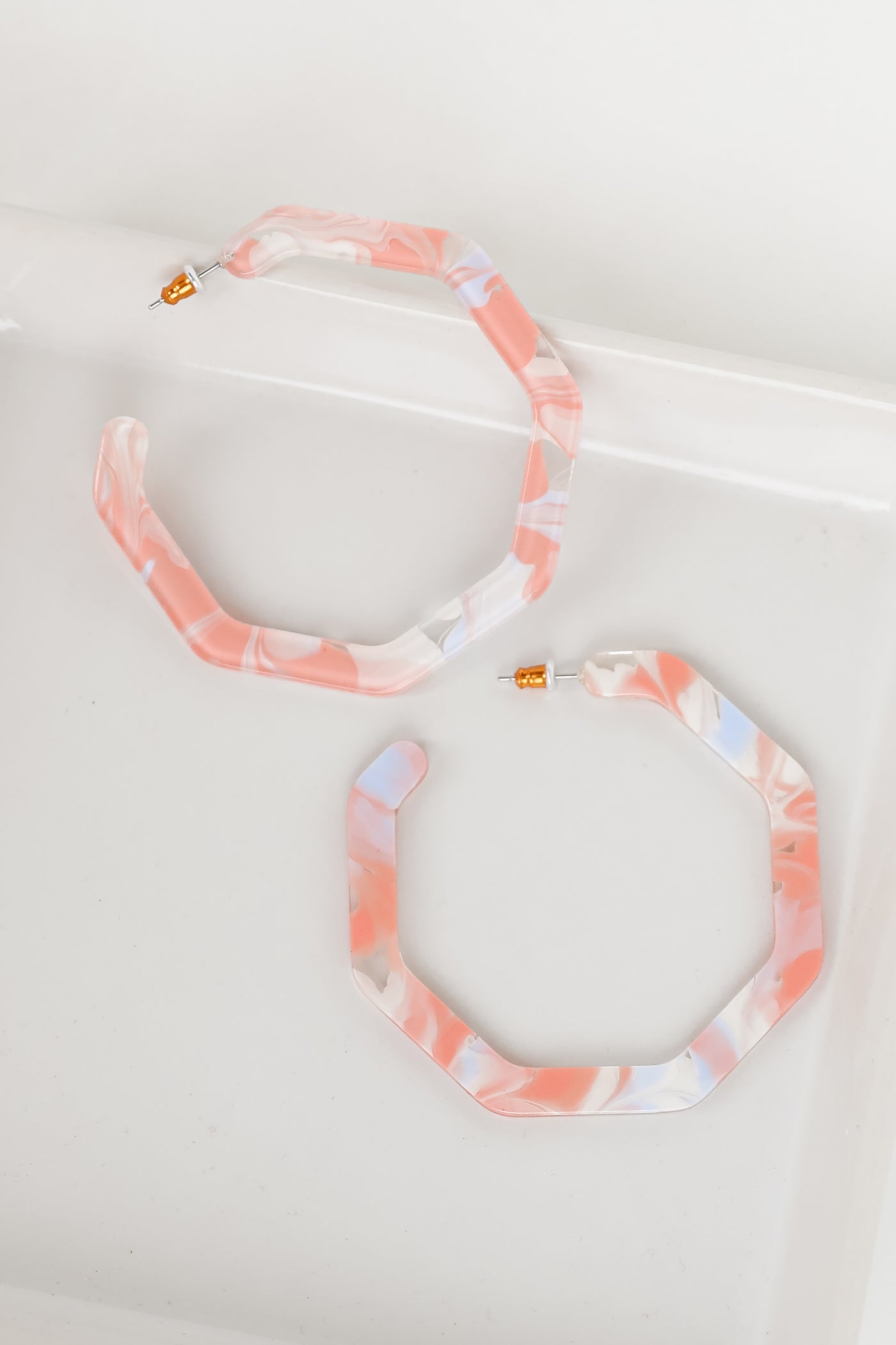 Acrylic Geometric Hoop Earrings in pink flat lay