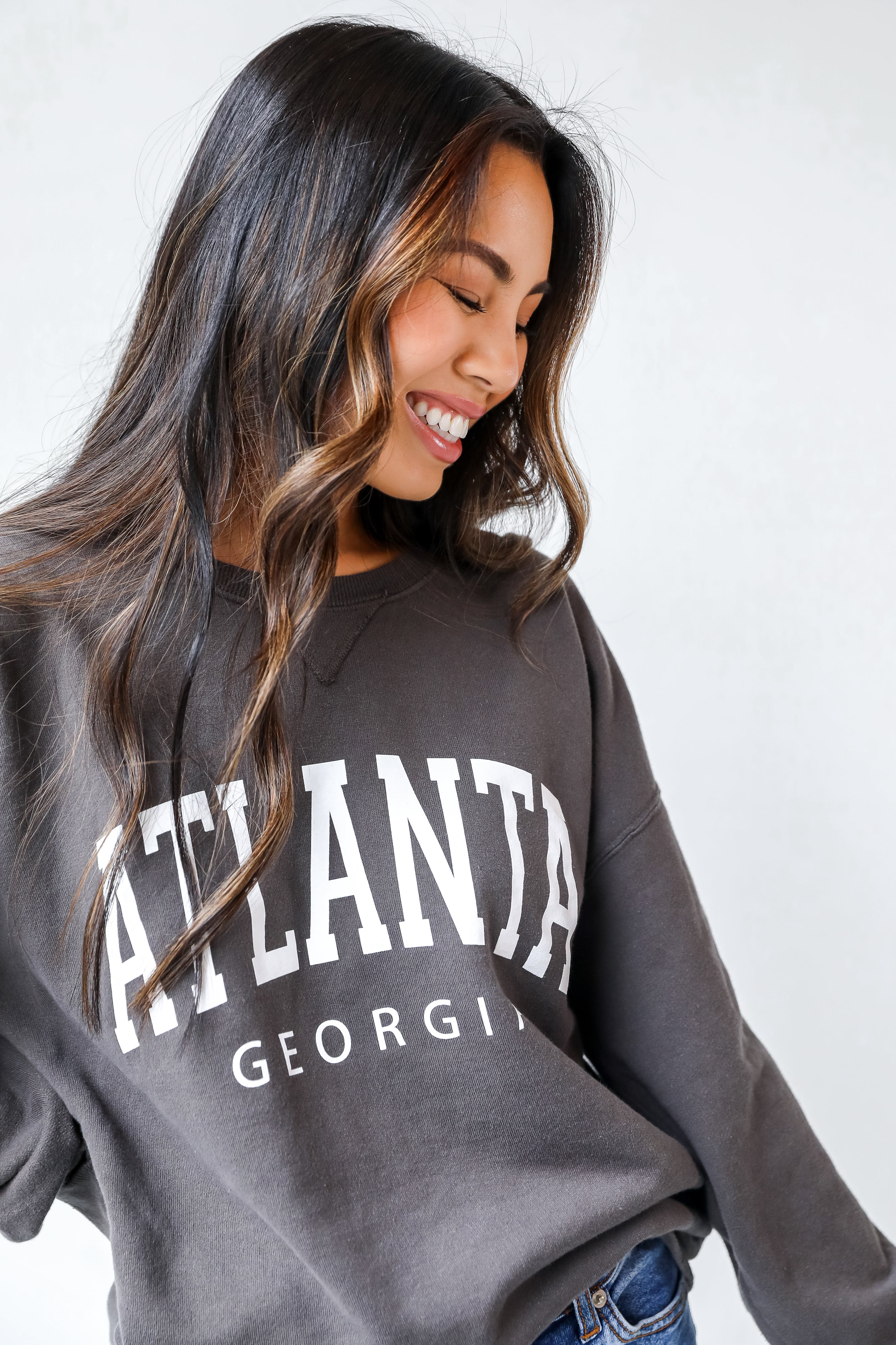 This comfy sweatshirt is designed with a soft and stretchy knit with a fleece interior. It features a crew neckline, long sleeves, a relaxed fit, and the words &quot;Atlanta Georgia&quot; on the front.