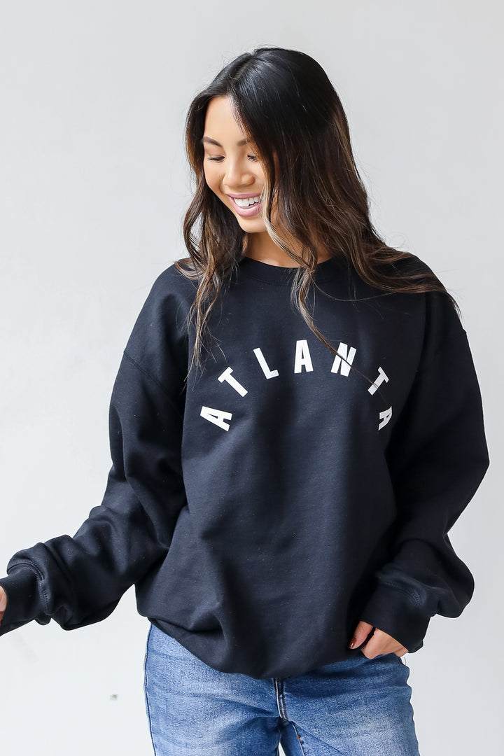  This comfy sweatshirt is designed with a soft and stretchy knit with a fleece interior. It features a crew neckline, long sleeves, a relaxed fit, and the word "Atlanta" on the front. 