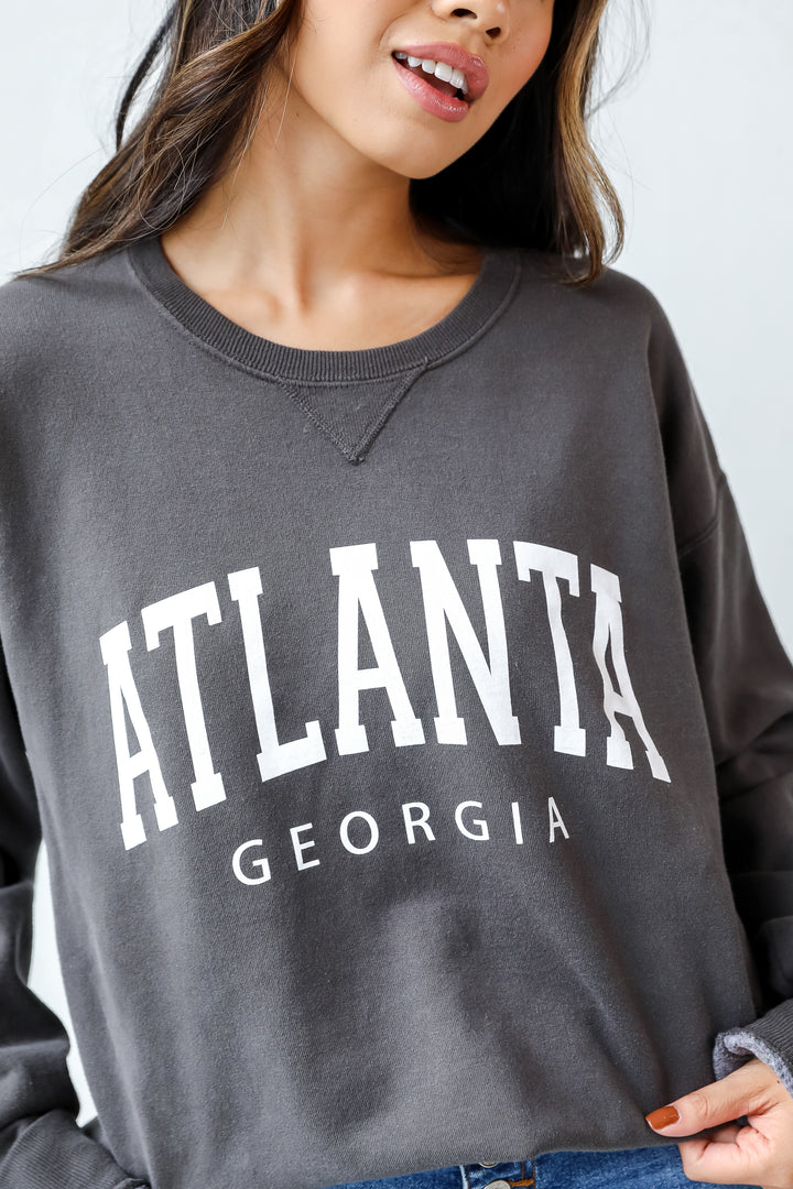 This comfy sweatshirt is designed with a soft and stretchy knit with a fleece interior. It features a crew neckline, long sleeves, a relaxed fit, and the words "Atlanta Georgia" on the front.
