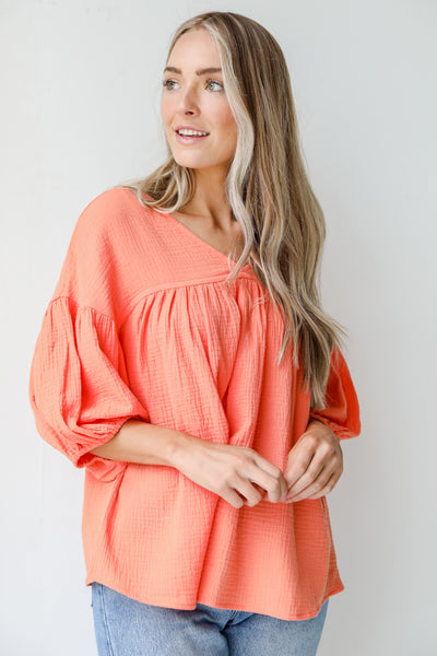 Linen Babydoll Blouse in coral on model