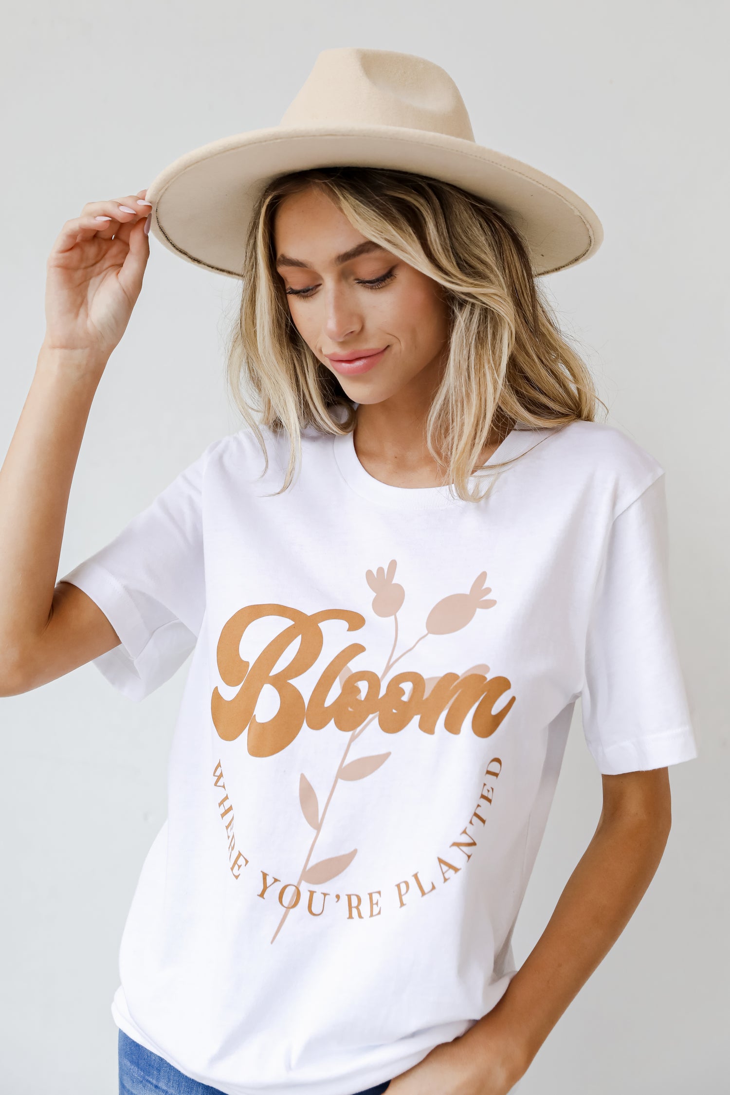This comfy tee is designed with a soft and stretchy knit. It features a crew neckline, short sleeves, a relaxed fit, and the words "Bloom Where You&