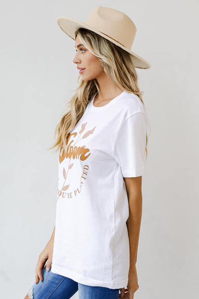 This comfy tee is designed with a soft and stretchy knit. It features a crew neckline, short sleeves, a relaxed fit, and the words "Bloom Where You're Planted" on the front.