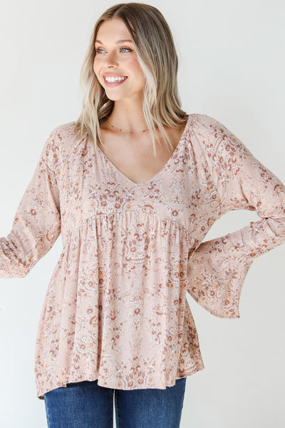 front view of a pink floral bell sleeve blouse